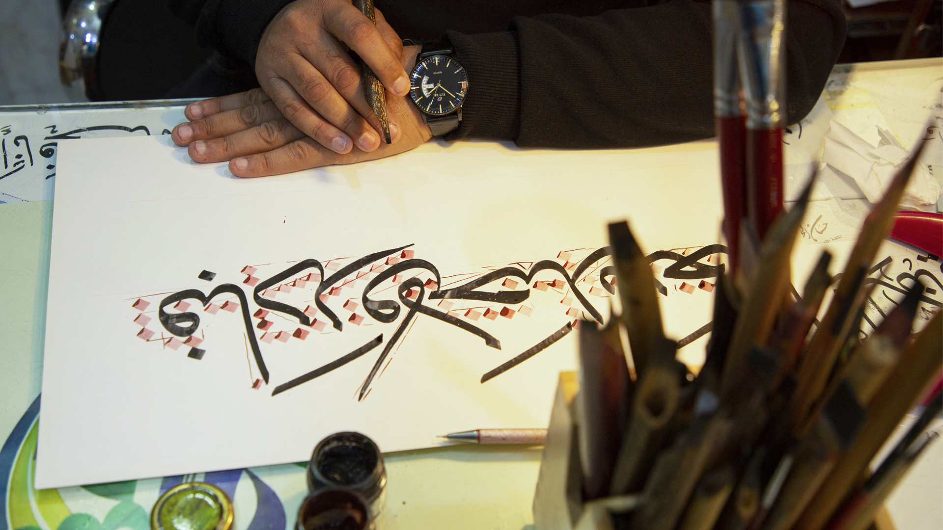 Iraqi calligrapher Wael Ramadan uses a stylus to produce a sample of Arabic calligraphy at his workshop in al-Ashar district of Iraq's southern city of Basra, Dec. 21, 2021. (Photo: Hussien Faleh/AFP)